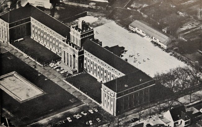 Schulgebäude mit Pavillon und zerstörtes Wasserbecken nach 1962.